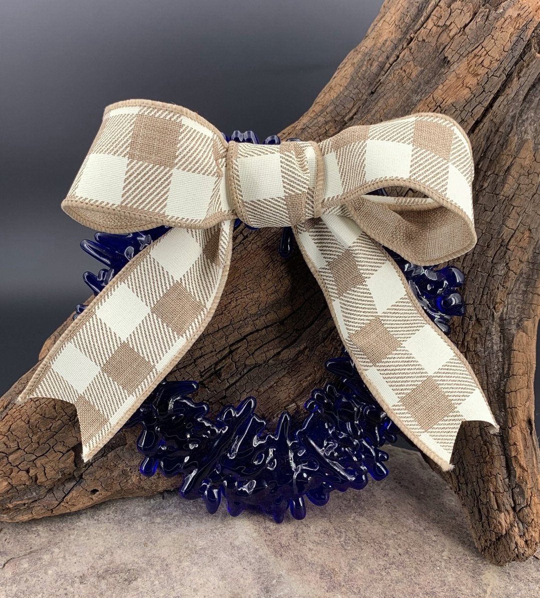 a handmade blue recycled glass wreath with a tan and white plaid bow