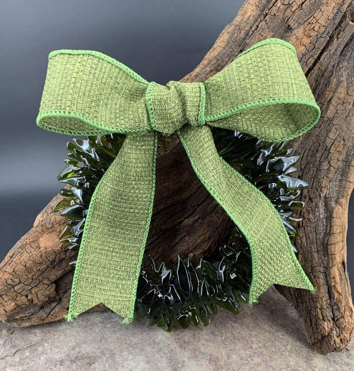 a handmade green glass wreath from a recycled wine bottle with a green ribbon bow