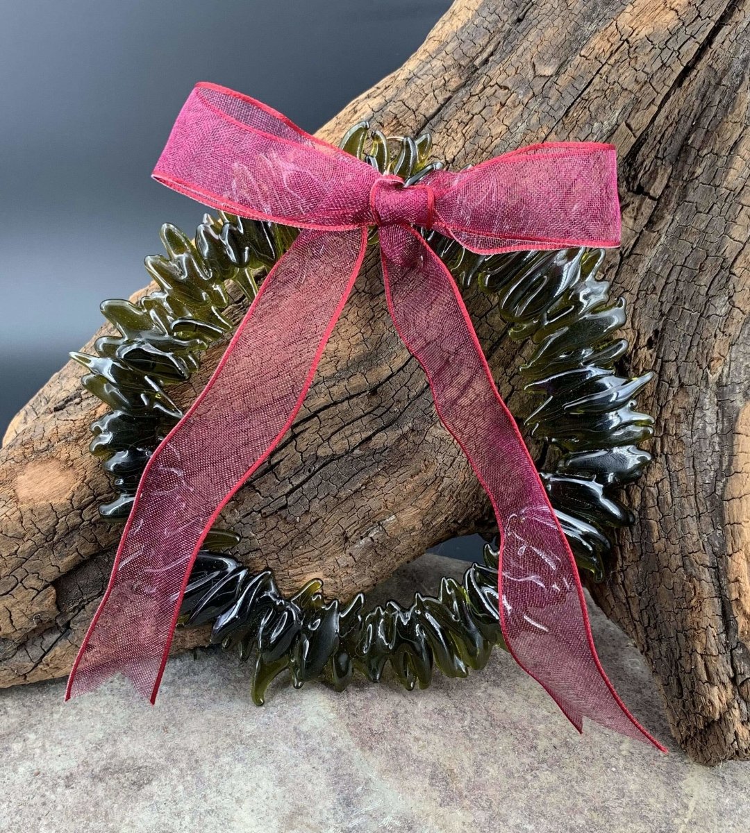 a handmade green glass wreath from a recycled wine bottle with a red and white plaid ribbon bow