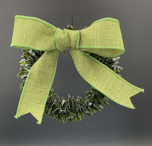 a handmade green glass wreath from a recycled wine bottle with a green ribbon bow