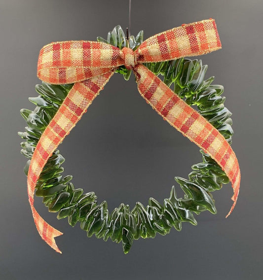 a handmade green glass wreath from a recycled wine bottle with a red and white plaid ribbon bow