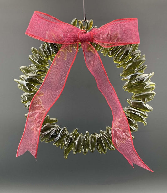 a handmade green glass wreath from a recycled wine bottle with a red ribbon bow