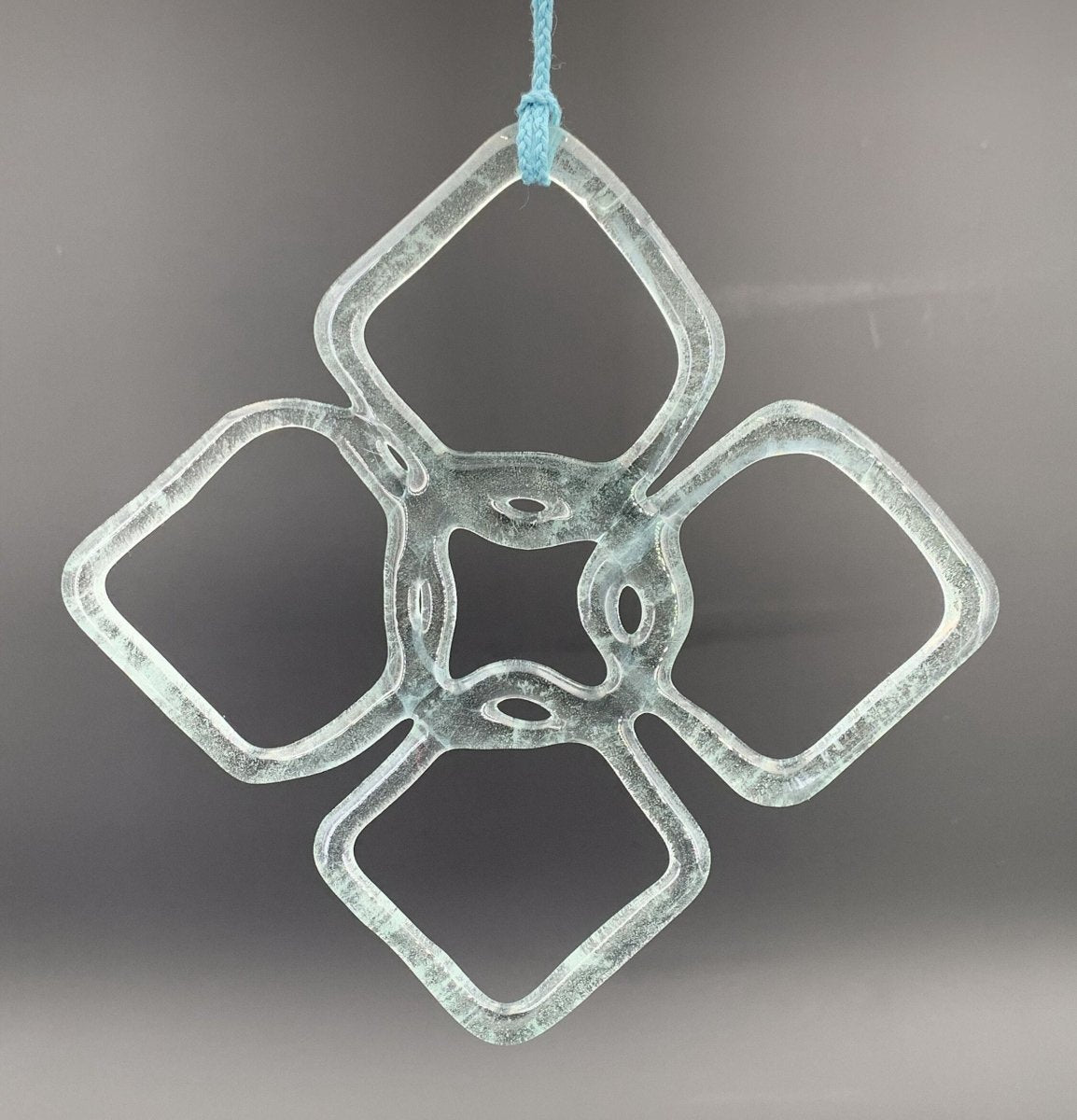 a handmade flower shaped suncatcher from aqua glass recycled from a wine bottle