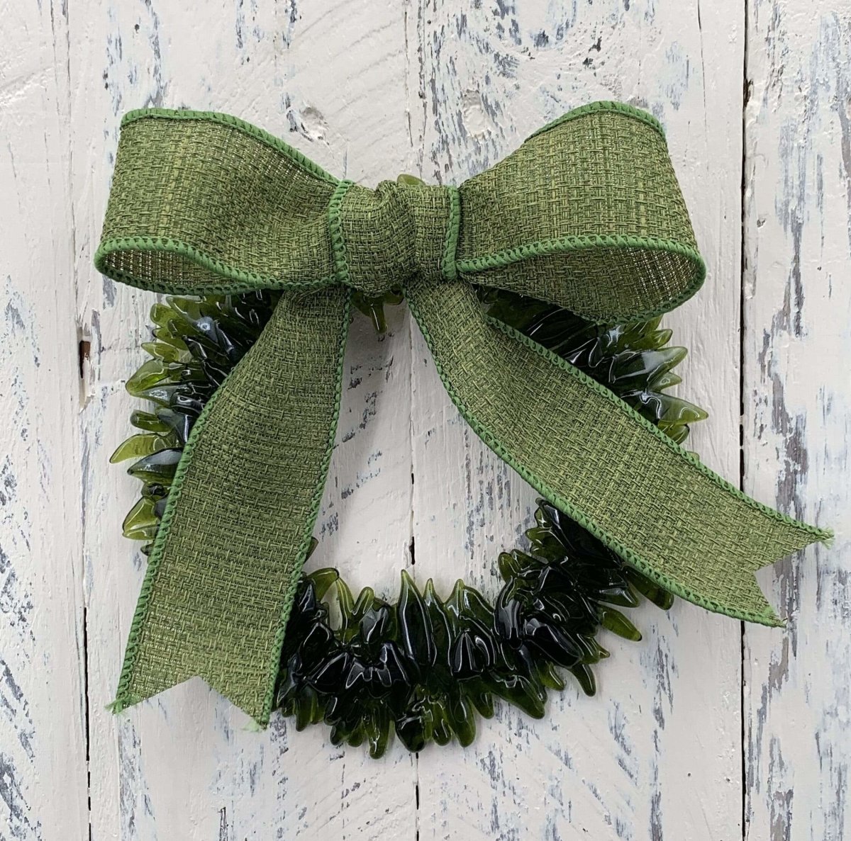 a handmade green glass wreath from a recycled wine bottle with a green ribbon bow