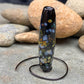 a handmade lampworked glass bead with multicolor dots on a black background