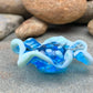 a handmade lampworked blue glass bead with a blue glass ruffle with white dots around the middle of the bead.