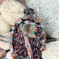 a handmade pendant from recycled glass that has been electroformed with copper and had a patina applied
