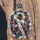 a handmade pendant from recycled glass that has been electroformed with copper and had a patina applied