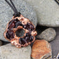 a handmade pendant from recycled glass that has been electroformed with copper